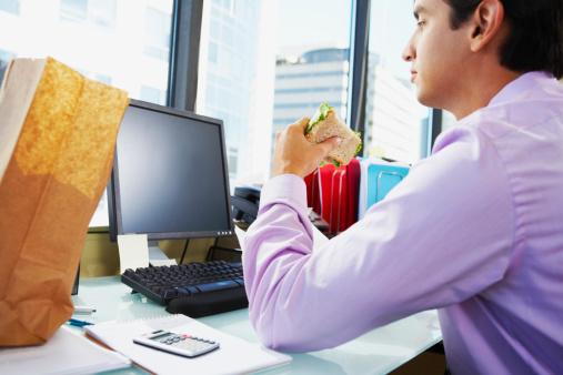 man eating lunch at desk