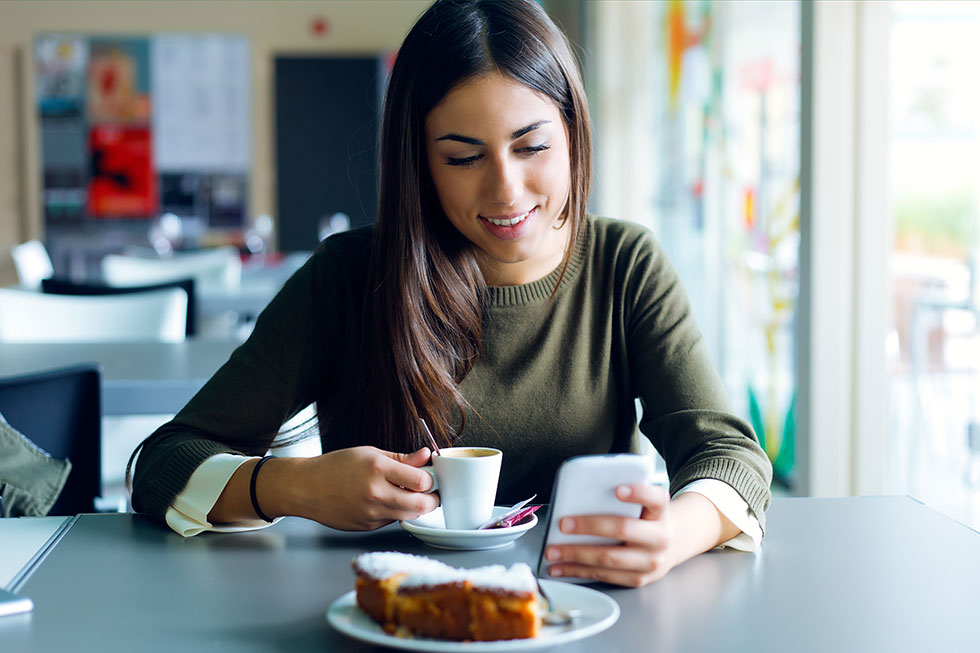 Woman checking phone in coffee shop