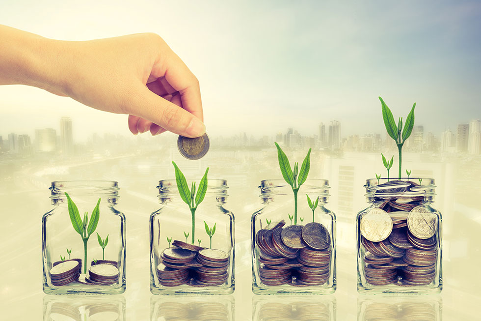 Hand placing coins in jars to save money