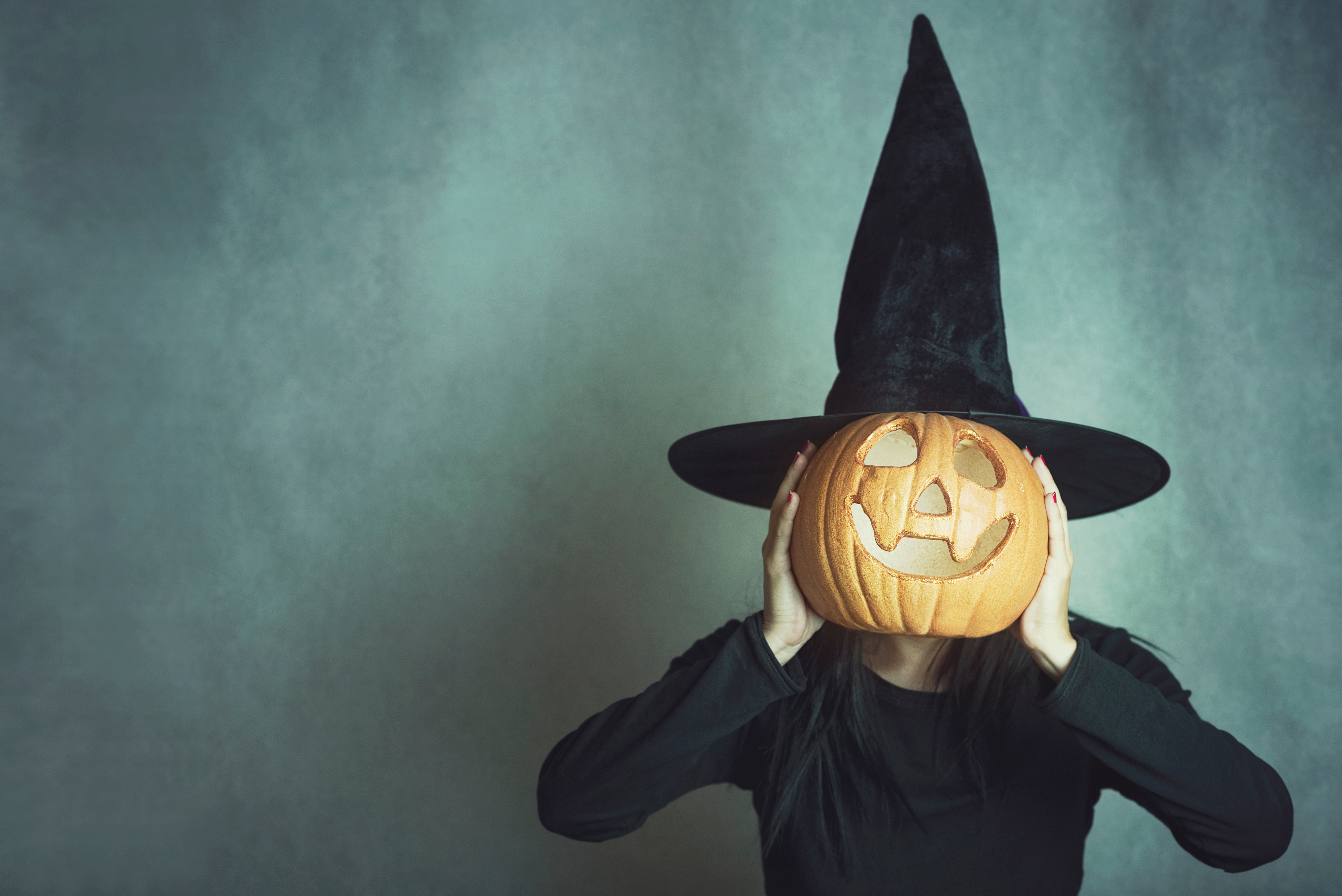 Halloween picture of someone holding a pumpkin over their face